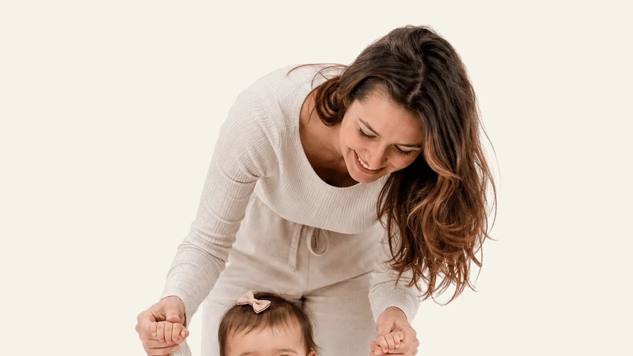 An active one year old dancing with a parent's support during a sleep regression