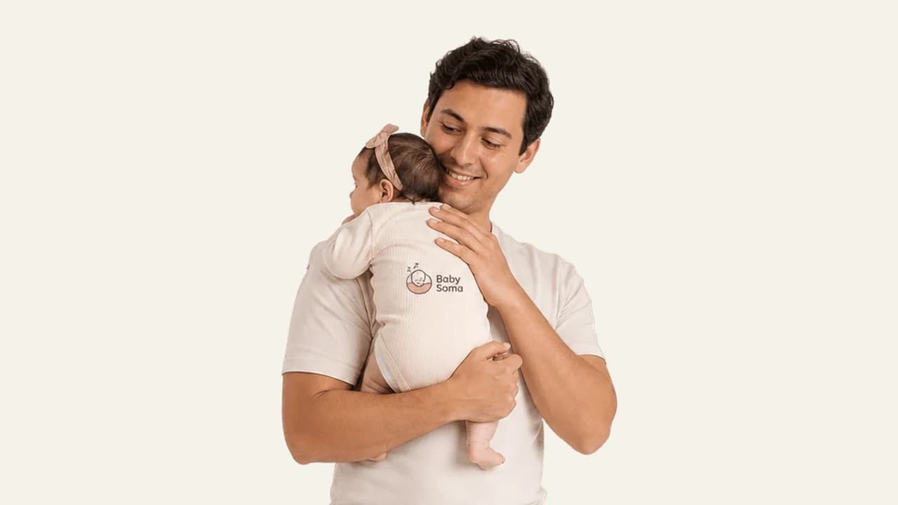 A fussy baby resting against a parent's shoulder while fighting sleep
